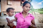 A teenage mother of two, carries her youngest child outside their makeshift shelter in the hinterlands of the northern Philippine province of Cagayan. Photo: UCAN/Mark Saludes