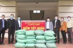 Caritas workers give rice to Quyet Thanh Commune officials on March 2. Photo: UCAN/courtesy of gphaiphong.org