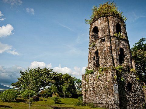In the shadow of the volcano centuries old church tower stands tall