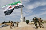 Turkish-backed Syrian rebel fighters raise the Syrian opposition flag at the border town of Tel Abyad, Syria, on October 14. Photo: CNS/Reuters