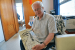 Father Doimo with a compilation of his compositions.