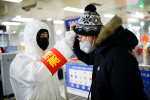 A passenger entering a Beijing subway station gets a temperature check on January 28. Photo: CNS/Reuters