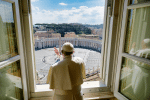 Standing in the window of the library of the Apostolic Palace overlooking an empty St. Peter’s Square, Pope Francis blesses the city of Rome on March 15. Photo: CNS/Vatican Media via Reuters