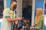 A member of Catholic Youth in Bandung, West Java, giving aid items to a Muslim woman. Photo: UCAN/Edi Silaban