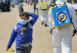 An internally displaced Syrian girl wears a protective face mask as members of the Syrian Civil defense force sanitise the Bab Al-Nour camp on March 26. Photo: CNS/Reuters