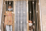 Children with facemasks look out the window of their home in Sanaa, Yemen, on June 7. Photo: CNS/Reuters