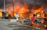 In this 2013 photo, houses burn in a residential district on the island of Mindanao, following clashes between goverment forces and Musliim rebels. File photo: CNS/Reuters