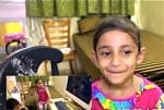 A girl sharing her joy of having a computer at home. Photo: Screenshot/ Caritas Computer Workshop
