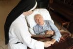 A Dominican nun chats with a patient at a palliative care facility. Photo: CNS