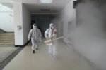 Volunteers in personal protection equipment disinfect a residential compound in Wuhan. Photo: CNS/China Daily via Reuters
