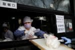 Servers wear facemasks at restaurant takeout counter in Beijing. Photo: CNS/Reuters