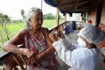 A woman receives the Oxford-AstraZeneca Covid-19 vaccine from a municipal health worker near the banks of the Solimoes River, in Manacapuru, Amazonas state, Brazil, on February 1. Photo: CNS/Reuters
