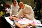 A priest anoints a sick woman during World Day of the Sick in Manila in 2018. Photo: UCAN/Angie de Silva