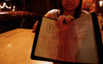 A girl working in a bar shows the fake passport that enabled her to travel abroad where she was required to “service” at least five male customers a day. File photo: UCAN/Vincent Go