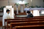 A priest administers absolution for a penitent after a socially-distanced confession at a church in Rome. Photo: CNS/Reuters