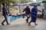 Medical volunteers carry an injured anti-coup protester who was shot during a clash with security forces in Mandalay, Myanmar, on March 21. Photo: CNS/Reuters