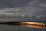 A man swims next to a manmade wall built to protect the island of South Tarawa from rising tides in the central Pacific island nation of Kiribati, in May 2013. File photo: CNS/Reuters