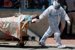 A health care worker wearing personal protective equipment pulls Covid-19 a patient on a stretcher outside Guru Teg Bahadur hospital in New Delhi on April 24. Photo: CNS/Reuters