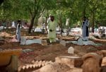 Mourners pray next to the graves of their relatives who died after contracting Covid-19 in India. Photo: CNS /Amit Dave, Reuters