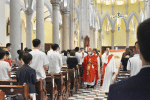 Cardinal Tong sprinkling holy water on the newly-baptised.