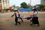 Myanmar Red Cross volunteers carry a person shot during a security force crackdown on anti-coup protesters in Yangon on March 14. Photo: CNS/Reuters