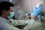 A scientist is pictured in early July at a university lab in Athens, Greece, working on cells that produce antibodies against Covid-19. Photo: CNS /Alkis Konstantinidis, Reuters