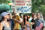 A woman holds a sign during a protest against mandatory Covid-19-vaccines outside New York City Hall on August 16. Photo: CNS/Jeenah Moon, Reuters