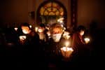 Worshippers holding candles and wearing protective masks pray during the Easter Vigil in Shanghai on April 3, during the Covid-19 pandemic. Photo: CNS/Aly Song, Reuters