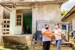 Thanks to CHARIS, a volunteer from St. Damian Parish in Batam, Indonesia, is able to distribute food to a family. Photo: UCAN/Catholic News
