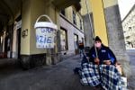 A homeless person in Turin, Italy, uses a fishing rod to maintain social distancing because of Covid-19 as he begs for money. Photo: CNS/Massimo Pinca, Reuters