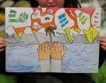 a student at St. Conval's Primary School holds a poster about climate change ahead of the UN Climate Change Conference, COP26, in Glasgow, Scotland, on October 19, 2021. Photo: CNS/Russell Cheyne, Reuters