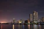 amazing cityscape with modern illuminated skyscrapers on embankment at night