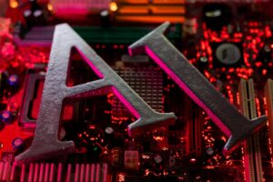 Close-up of a computer motherboard with large metallic letters A and N resting on red-lit circuitry and components nearby.