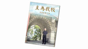 Man in black clothing standing under an arched stone gateway on a tilted poster or board with Chinese text above him, urban trees in the background.